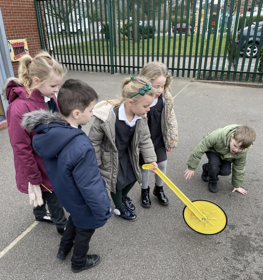 Measuring the classroom and playground in metres using a trundle wheel 
